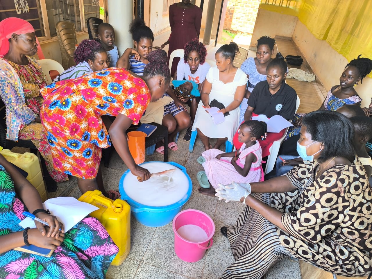 A group gathered around a basin during a soap making demonstration