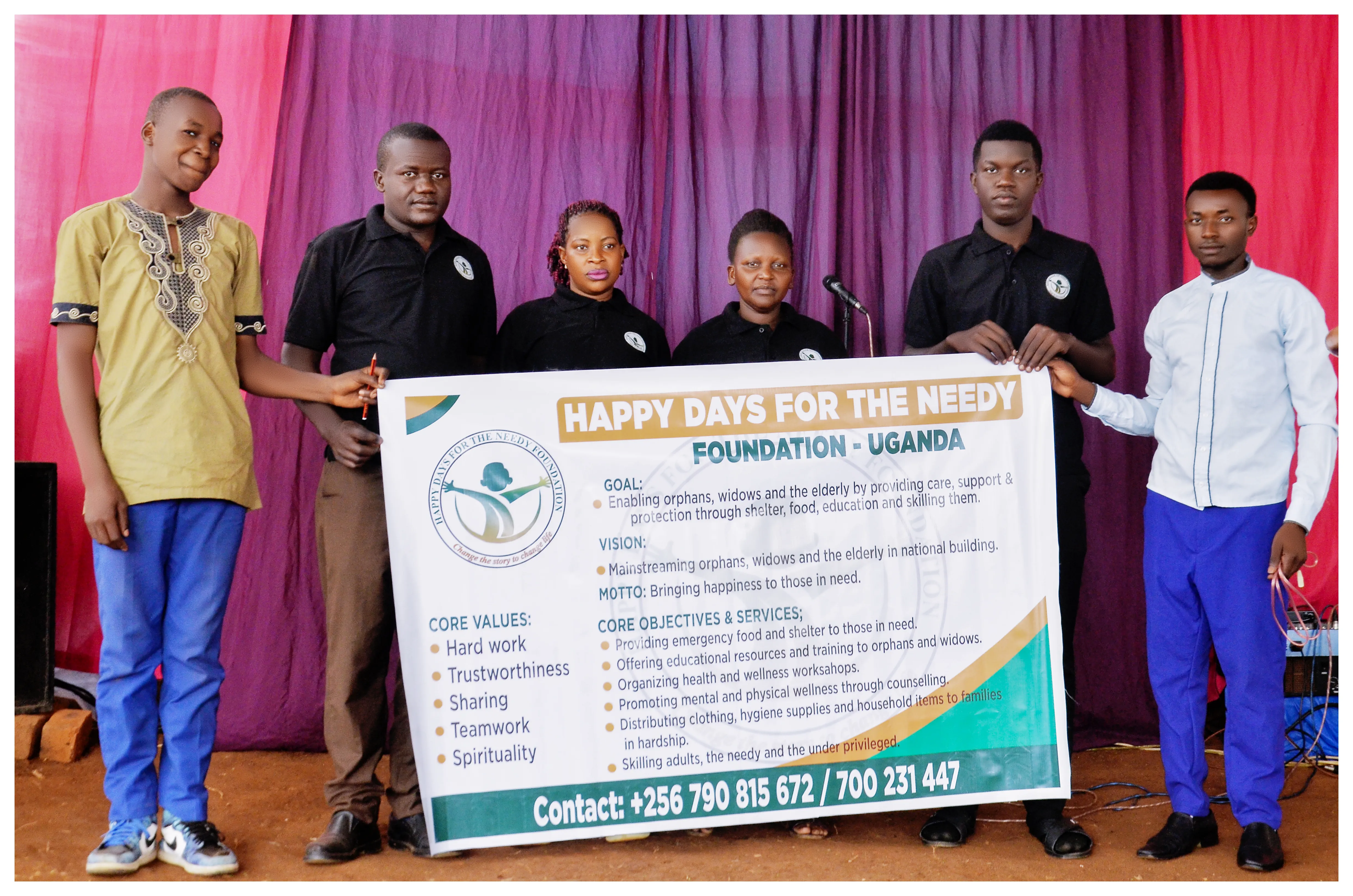 Six team members holding the Happy Days for the Needy Foundation banner