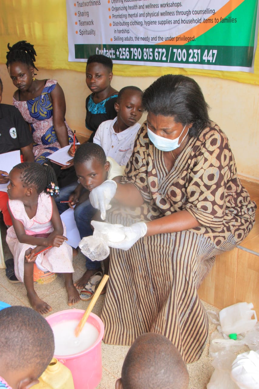 A trainer demonstrating liquid soap making to a seated group